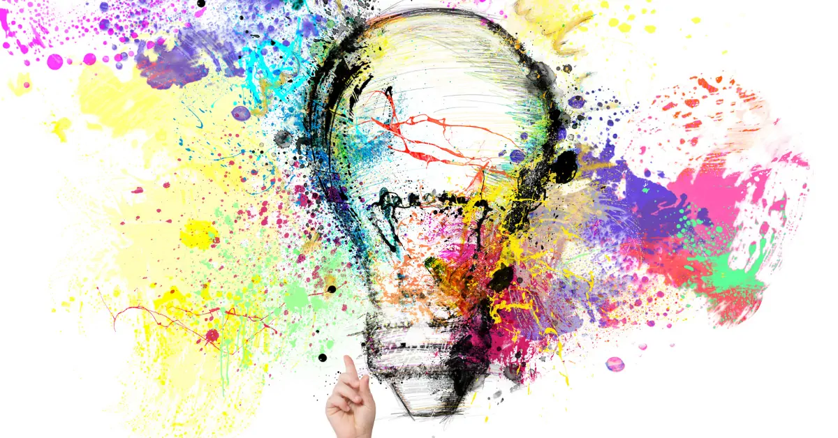 An image of a lightbulb surrounded by brightly coloured powder paint representing creativity.