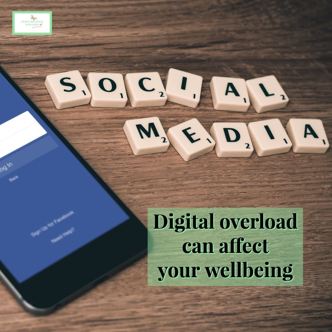 Living Creatively with Fibro | An image of a phone on a wooden table with tiles spelling social media The statement Digital Overload can affect your wellbeing