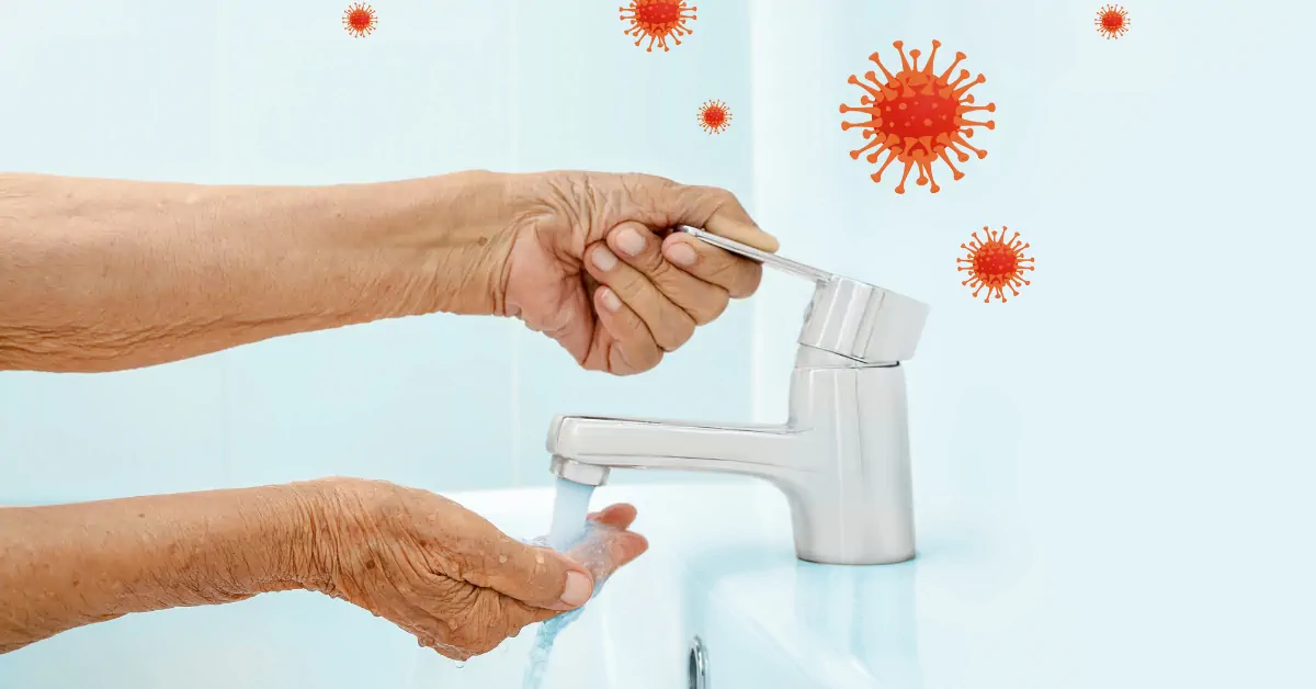 An image of someone washing their hands with germ particles floating around.