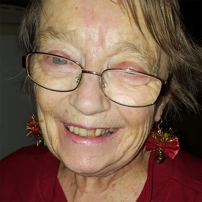 Joan wearing a red dress and earrings.