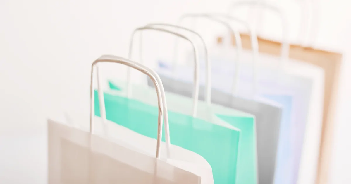 Stacked paper bags in white, mint green, grey & beige on white background, for shopping your stash.