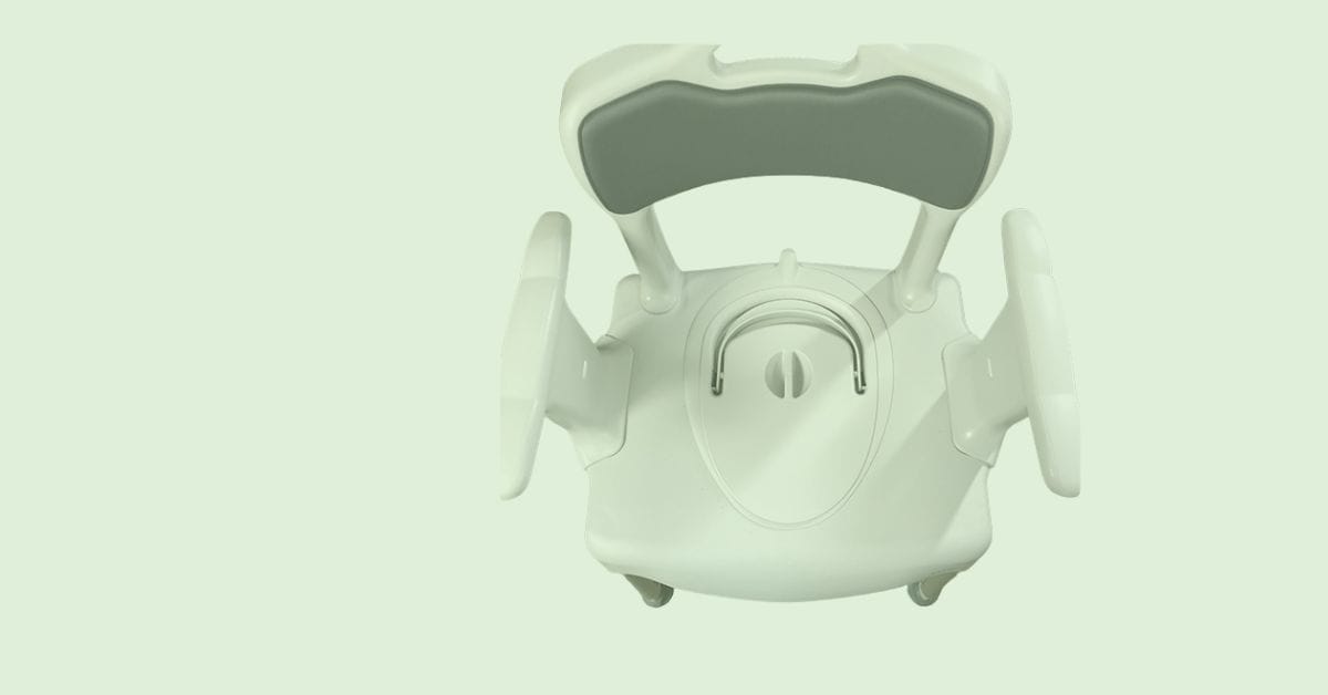 An armchair sat in the middle of the countryside with a lake behind.