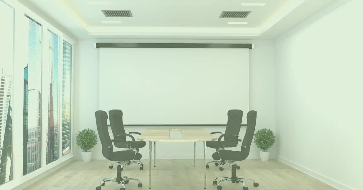 An armchair sat in the middle of the countryside with a lake behind.