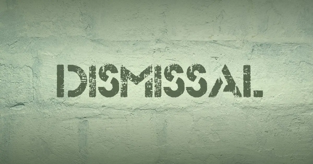 An armchair sat in the middle of the countryside with a lake behind.