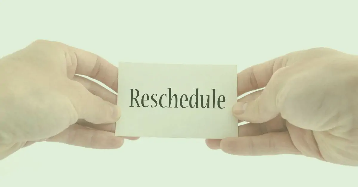 Two hands holding a card that says “Reschedule” – illustrating how postponing tasks when energy is low can prevent fibromyalgia flares and save the day.